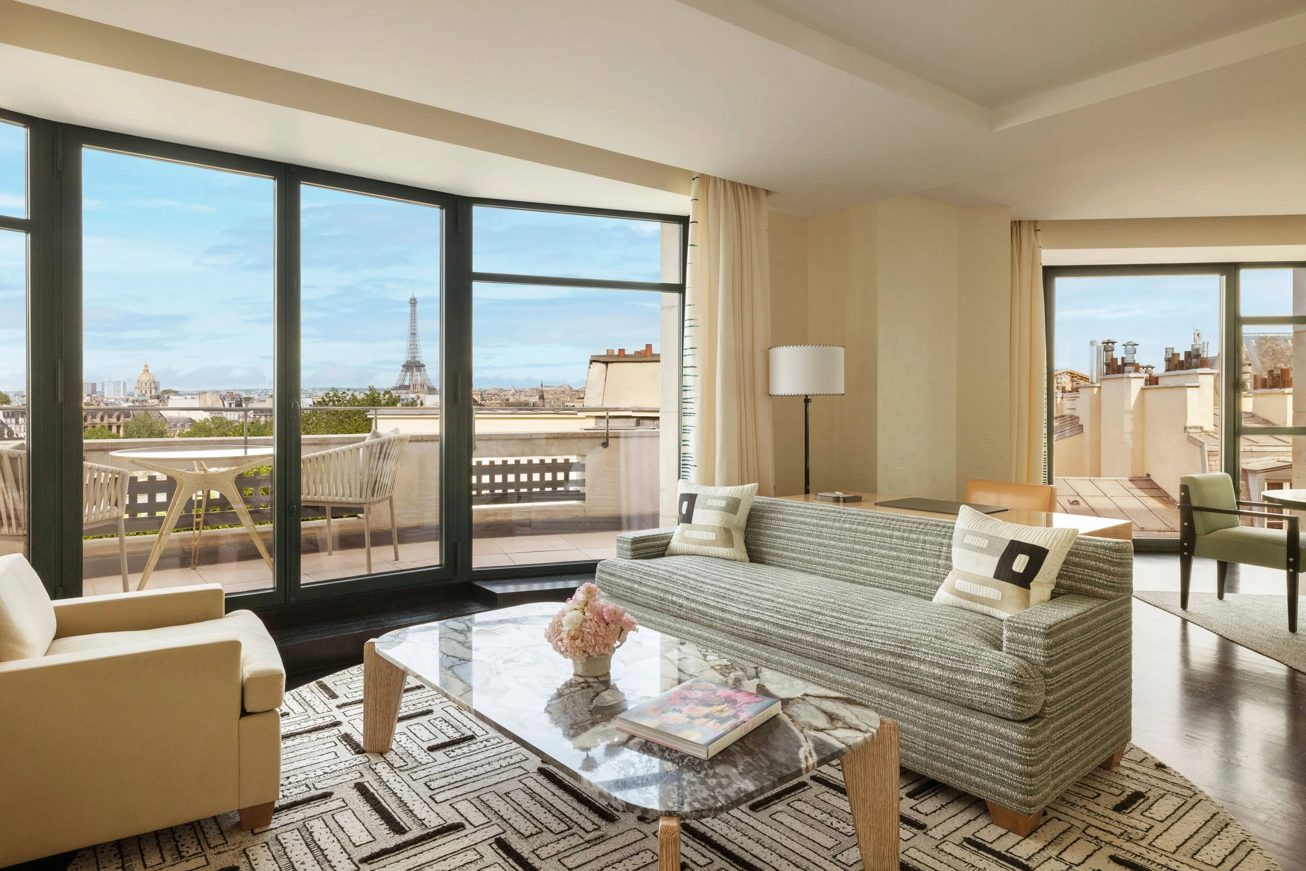 Sala de uma suíte do Cheval Blanc Paris com janelas para a cidade