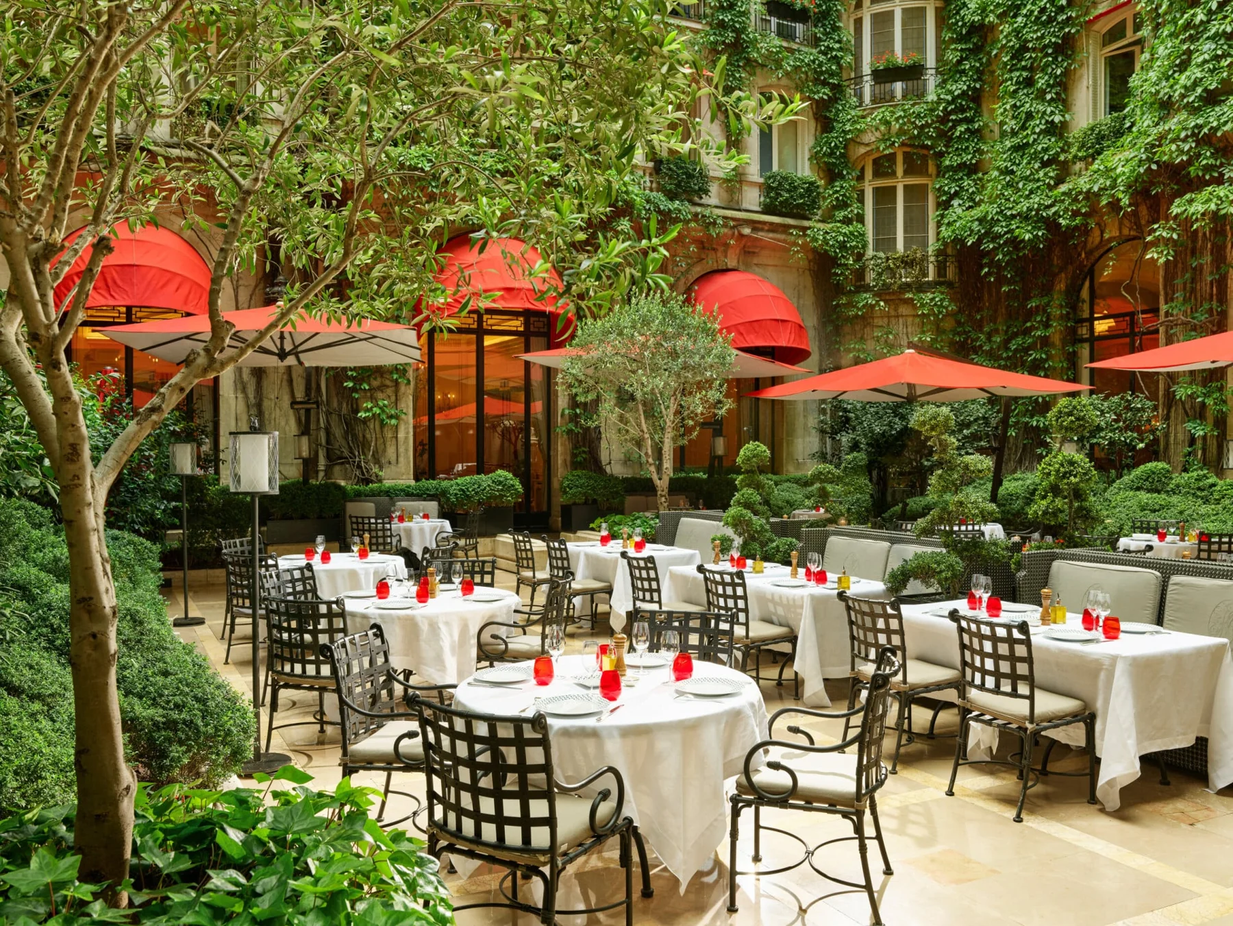 Mesas no pátio ajardinado La Cour Jardin do Hôtel Plaza Athénée