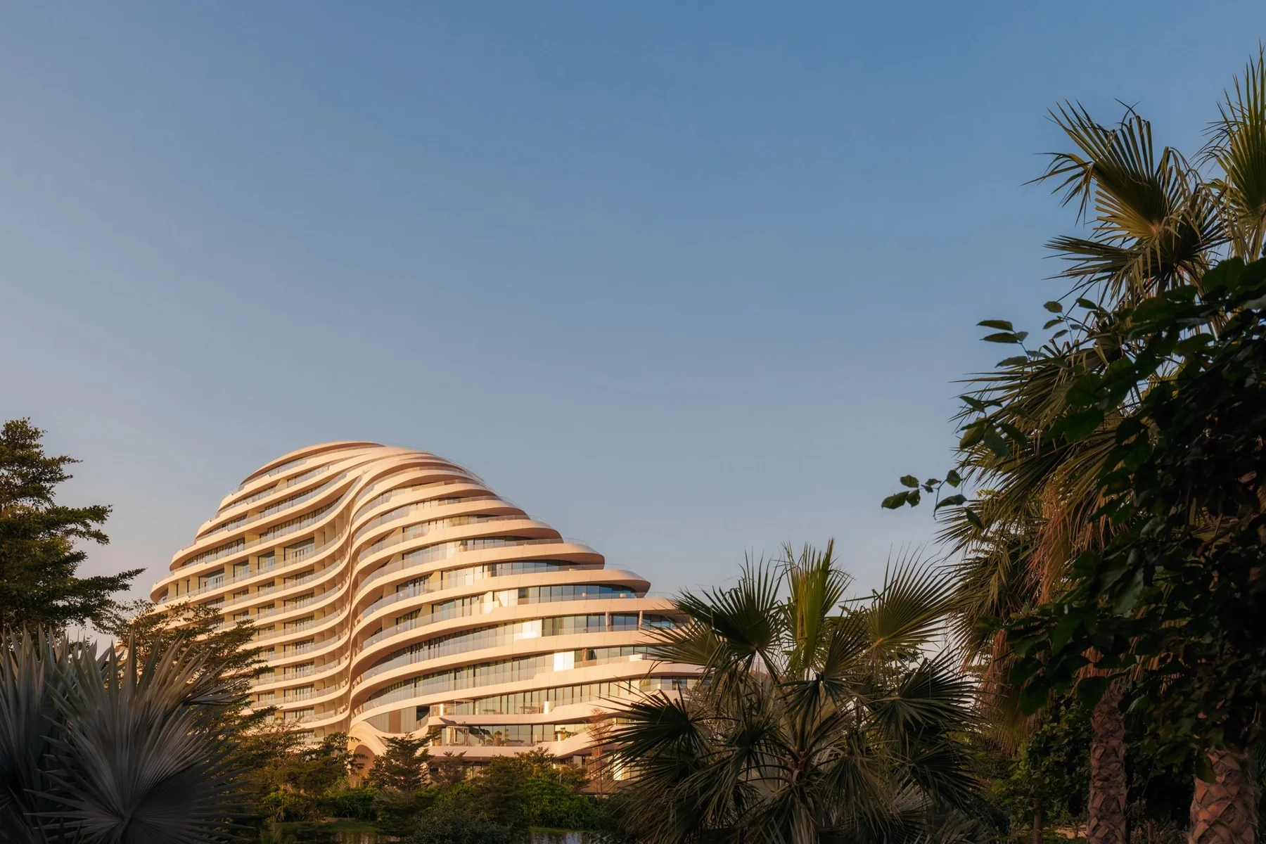 Arquitetura curva do Jumeirah Marsa Al Arab entre palmeiras