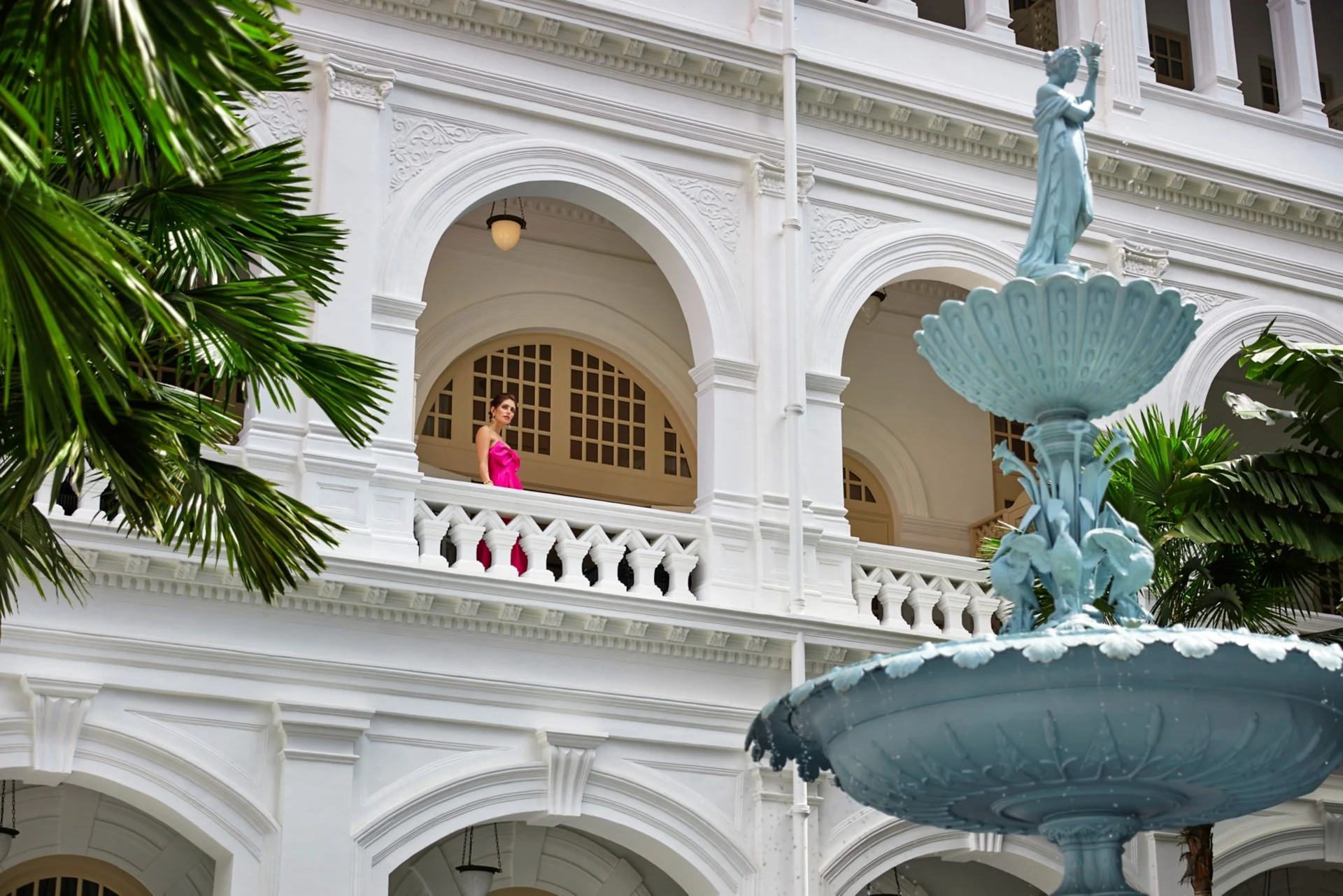 Fonte e pátio com arcos brancos no Raffles Singapore