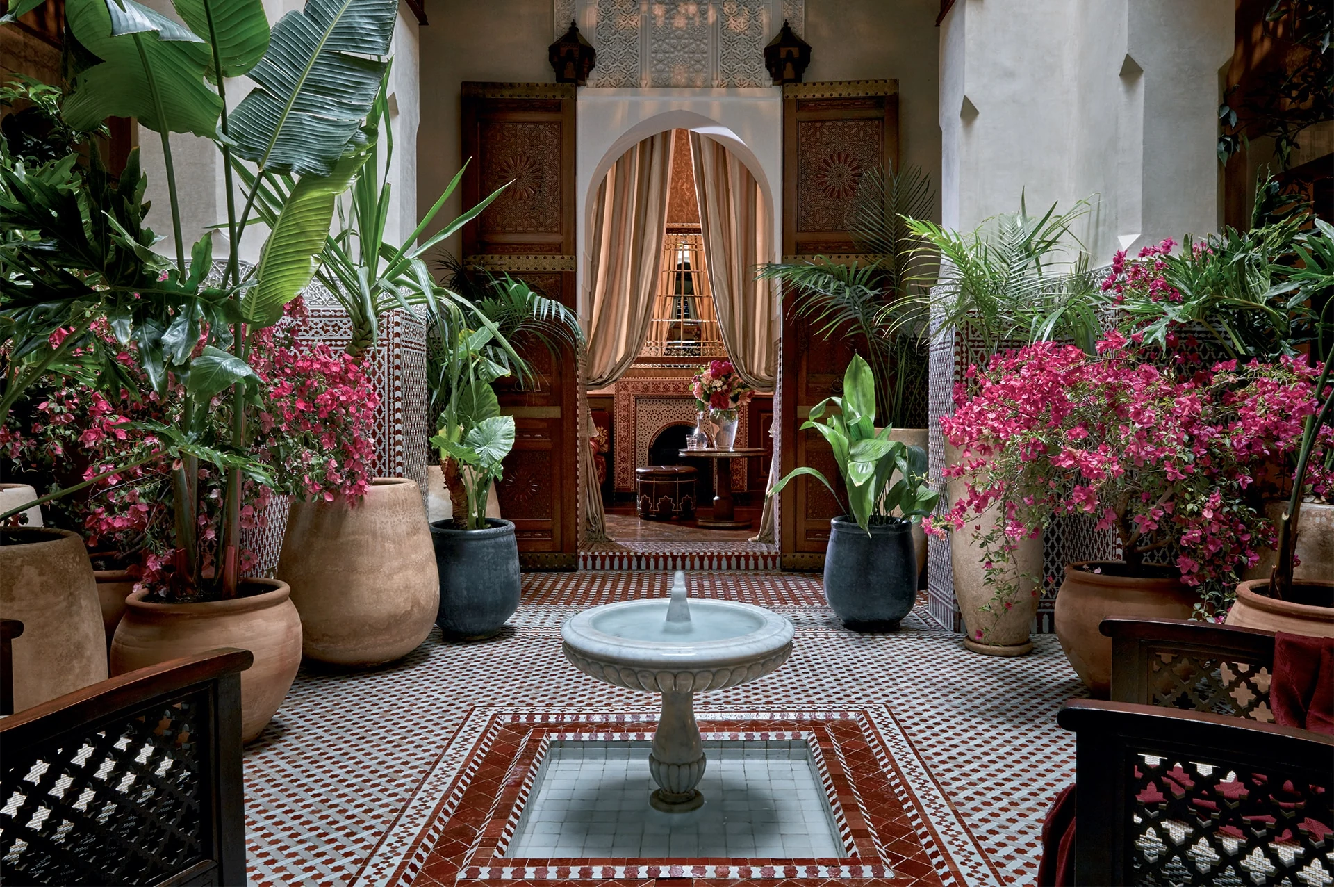 Pátio do riad com fonte, mosaicos e vegetação no Royal Mansour Marrakech