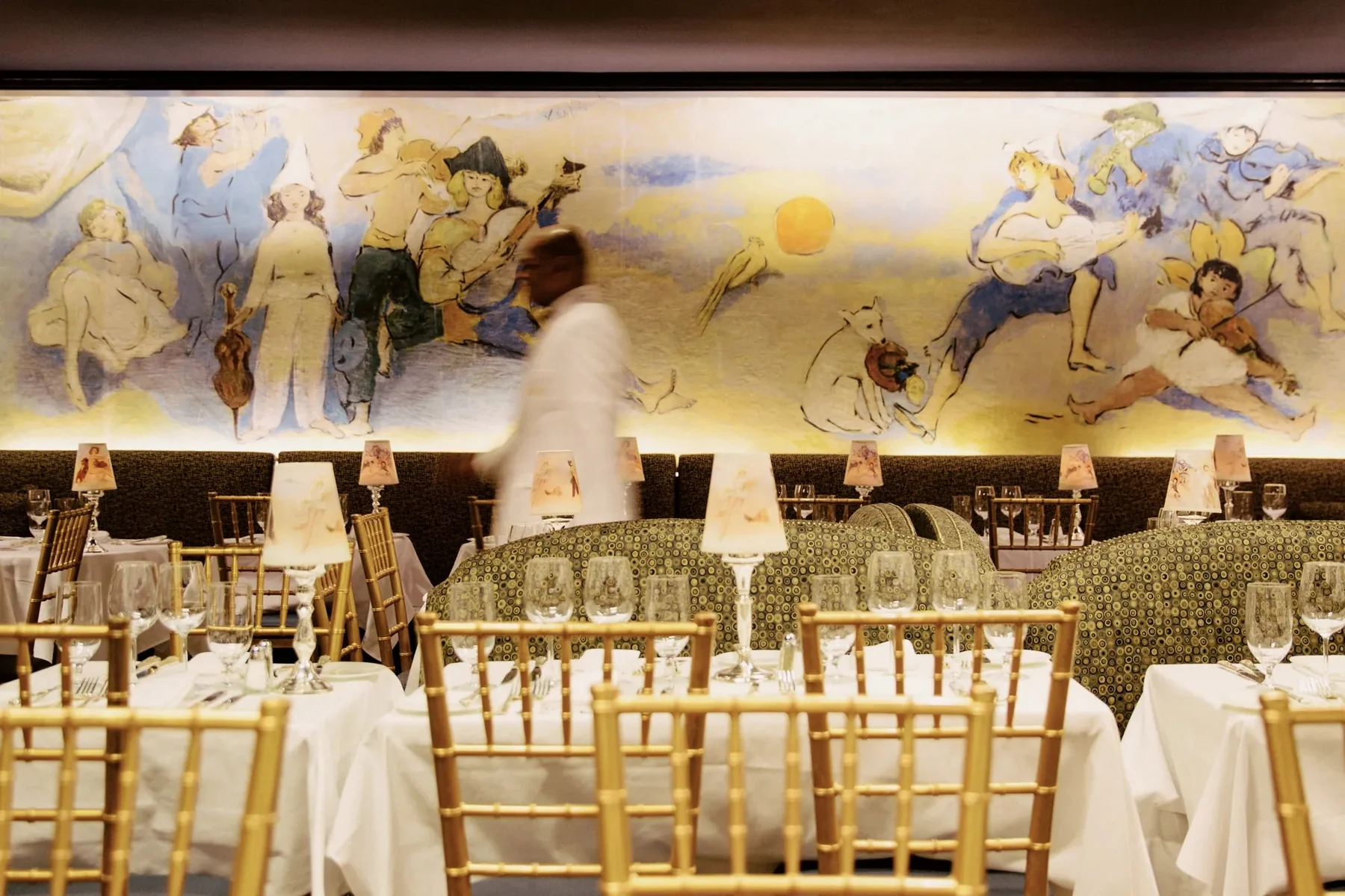 Café Carlyle com murais e mesas prontas para receber hóspedes