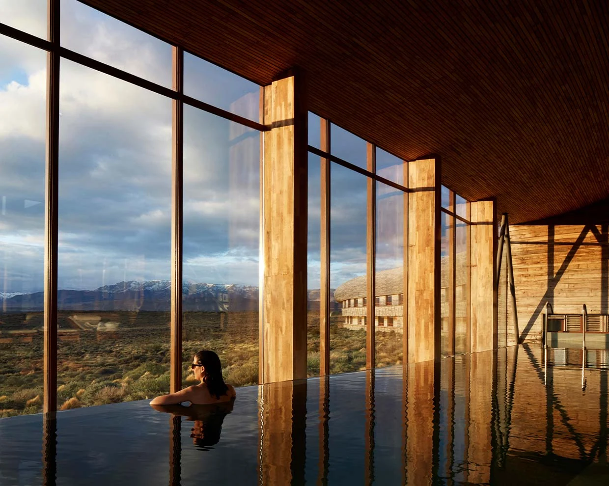 Piscina interna do Tierra Patagonia com janelas abertas à paisagem patagônica